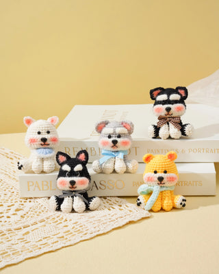 Handmade crochet dog and bear amigurumi plush toys with scarves and bows on books