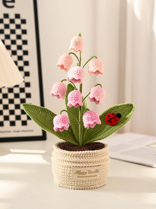 Handmade crochet pink flower arrangement in a cream pot with green leaves and a red ladybug