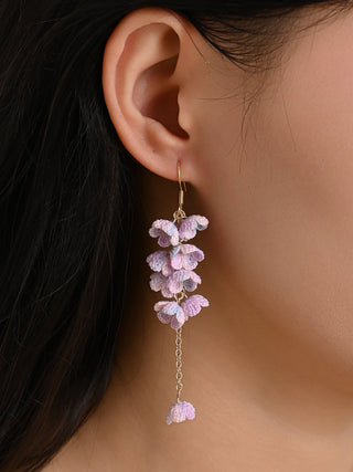 Close-up of an ear wearing a delicate pink floral earring.