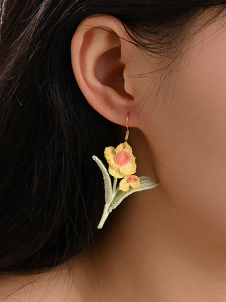 Close-up of an ear wearing a floral earring with a blurred background