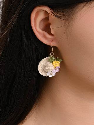 Close-up of a person wearing floral earrings with a neutral background