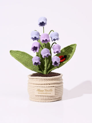Handmade crochet pot with purple bell flowers, green leaves and a red ladybird detail.