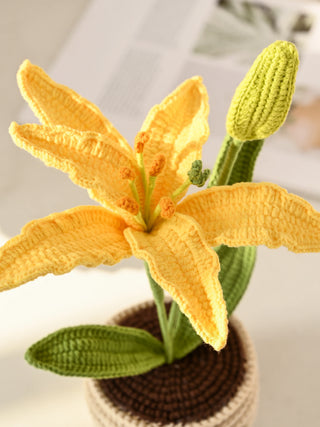 Handmade yellow crochet lily flower in a pot, amigurumi decor, close-up