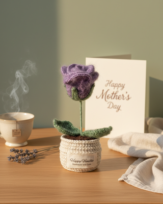 Handmade crochet purple flower in pot with Happy Mother's Day card on wooden table